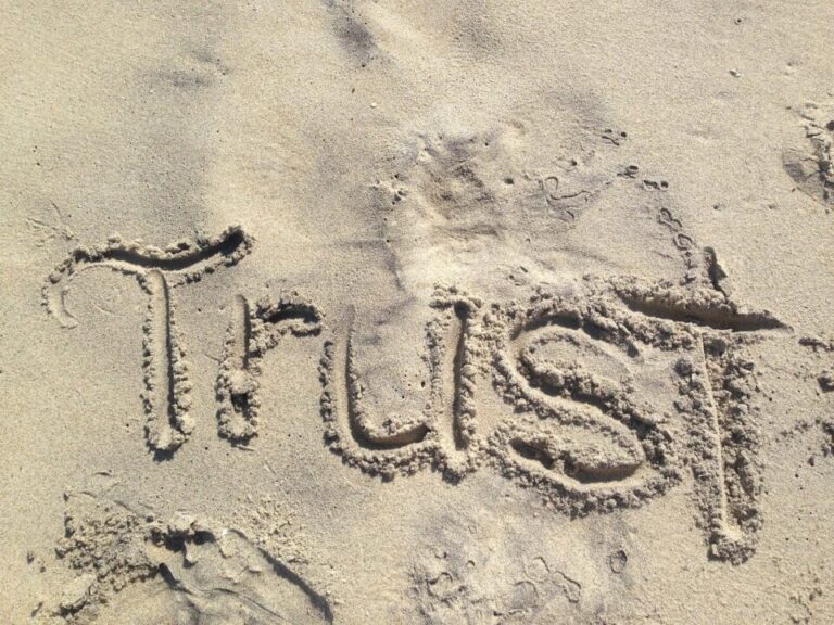 Das Wort "Trust" in den Sand gezeichnet